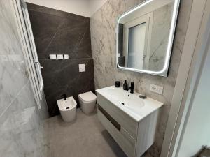 a bathroom with a sink and a toilet and a mirror at Casa sissy in Chioggia