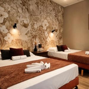 a hotel room with two beds with towels on them at Hôtel Abalone - Centre Gare in Nîmes