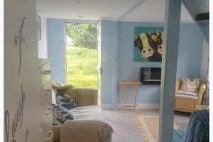 a living room with a couch and a cow on the wall at Inviting 1-Bed Cottage in Pontypridd in Pontypridd