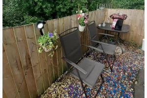 a garden with two chairs and a table and a fence at Inviting 1-Bed Cottage in Pontypridd in Pontypridd