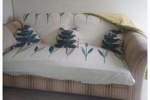 a white couch with four pillows on it at Inviting 1-Bed Cottage in Pontypridd in Pontypridd
