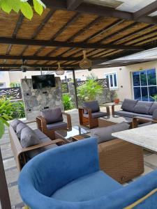 a patio with couches and tables and a stone wall at SeaLord Resort in Abuja