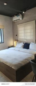 a bedroom with a large white bed with a window at SeaLord Resort in Abuja