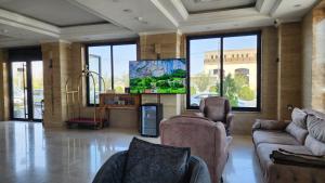 a living room with couches and a flat screen tv at Al Baron Hotel - فندق البارون in Al Mawşil