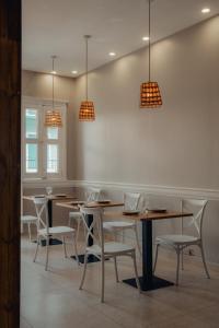 ein Esszimmer mit Tischen, Stühlen und Lampen in der Unterkunft Down Town Cozy in Pointe-à-Pitre