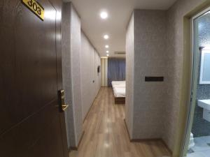 a hallway with a door and a bed in a room at Al Baron Hotel - فندق البارون in Al Mawşil +57 photos