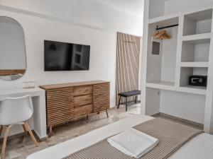 a bedroom with a bed and a television on a wall at My Place modern living in Kefalos