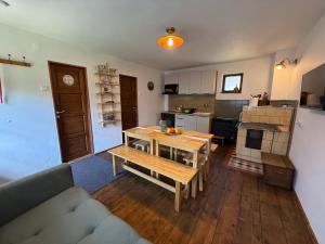 a living room with a table and a kitchen at Dvor u Hrivka in Heľpa