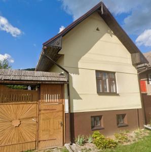 a house with a wooden gate and a fence at Dvor u Hrivka in Heľpa