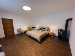 a bedroom with a bed and a flat screen tv at Dvor u Hrivka in Heľpa