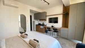 a bedroom with a large white bed and a kitchen at Apartamento com Piscina no Rooftop in São Paulo