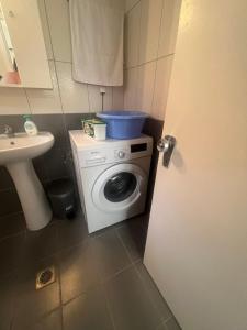 a bathroom with a washing machine and a sink at Paulos&Mary Apartment in Flogita