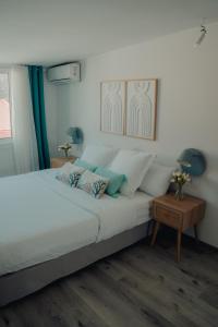 ein Schlafzimmer mit einem großen weißen Bett und einem Tisch in der Unterkunft Down Town Cozy in Pointe-à-Pitre