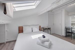 a bedroom with a white bed with two towels at Studio Centre Cannes, Rue d’Antibes in Cannes
