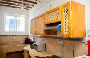 a kitchen with wooden cabinets and a sink at Boha Zanzibar Beach House in Bwejuu