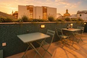 two tables and chairs on the roof of a building at Posada de los Venerables in Seville
