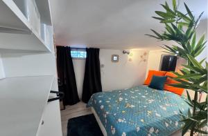 a small bedroom with a bed and a plant at Maison Gecko - Proche de la plage in Cavalaire-sur-Mer