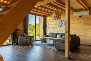 a living room with a couch and two chairs at Golden view Villa in Prishtinë