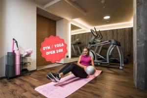 a woman sitting on a yoga mat in a gym at Hotel COSMEA - Your Dolomites & Honeymoon experience in Ortisei +156 photos