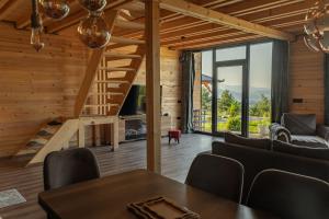 a living room with a staircase and a table and chairs at Golden view Villa in Prishtinë +13 photos