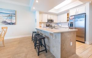 a kitchen with a large counter and stools in it at Phoenix Gulf Towers 706 condo in Gulf Shores