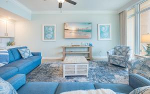 a living room with blue couches and a table at Phoenix Gulf Towers 706 condo in Gulf Shores +71 photos
