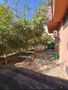 a walkway with benches and trees and a building at Marrakech héberg in Marrakesh