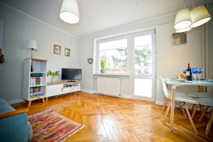 a living room with a table and a window at Merida Apartament in Sopot