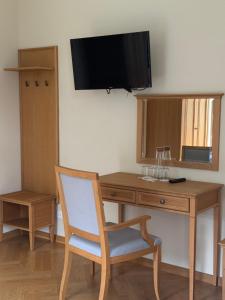 a desk with a chair and a television on a wall at Kasztanowy Pałac in Swadzim