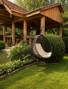 a hammock in a garden under a gazebo at Солочин Квітка Полонини Дом 63 in Solochyn