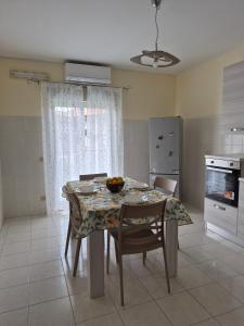 a kitchen with a table with chairs and a table and a table at The Citrus Balcony in Trappitello