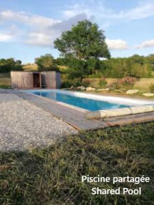 a swimming pool in a yard next to a house at Au Chalet Bourguignon 5 in Salives