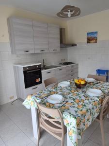 a kitchen with a table with a table cloth on it at The Citrus Balcony in Trappitello +7 photos