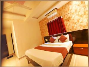 a hotel room with a bed and a red window at Udupi Grand Lodging and Boarding in Chākan