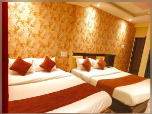 a hotel room with two beds in a room at Udupi Grand Lodging and Boarding in Chākan