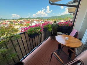 a balcony with a wooden table and flowers on it at Apartament SANOVA 55 in Sanok