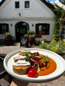 a plate of food with meat and vegetables on it at Gastland M1 Hotel & Conference Center in Páty