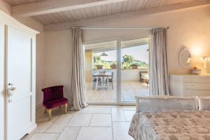 a bedroom with a bed and a chair and a patio at Villa Reginella - Rive del Salento in Lecce +63 photos