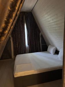 a bed in a small room with a window at Damla in İsmayıllı