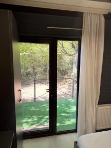 a bedroom with a sliding glass door to a yard at Damla in İsmayıllı +5 photos
