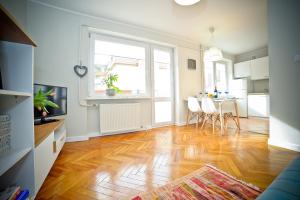 a living room with a hard wood floor and a kitchen at Merida Apartament in Sopot