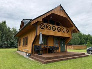 a house with a table and chairs on a deck at Piliakalnio Sodyba in Ilgininkai
