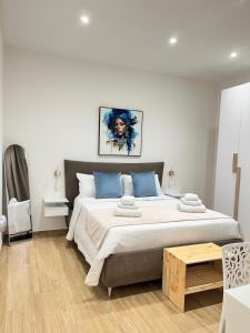ein Schlafzimmer mit einem großen Bett und blauen Kissen in der Unterkunft Marylen in Gela