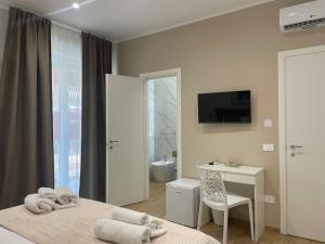 ein Schlafzimmer mit Bett, Schreibtisch und Fernseher in der Unterkunft Marylen in Gela