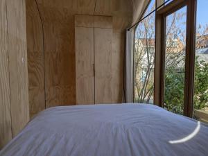 a bedroom with a bed and a large window at Bakkums Bosgeluk in Castricum