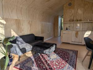 a living room with a couch and a table at Bakkums Bosgeluk in Castricum +8 photos