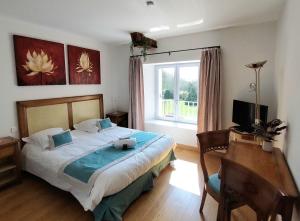 a bedroom with a bed and a desk and a window at Au Domelia Provinois - Chambres - in Cerneux