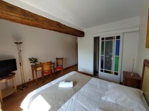 a bedroom with a white bed and a table and chairs at Au Domelia Provinois - Chambres - in Cerneux