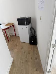 a television sitting on top of a white refrigerator at 1 Grande Chambre Frigo privé in Charleroi