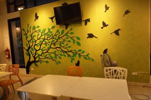a classroom with a wall with a tree and bats at 777 Food & Bed in Chiang Rai +24 photos